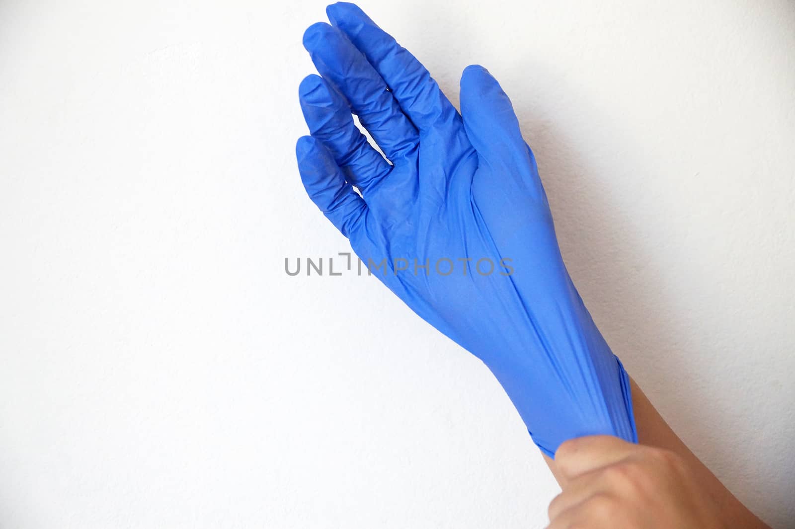 a medical glove is put on a hand close-up by Annado