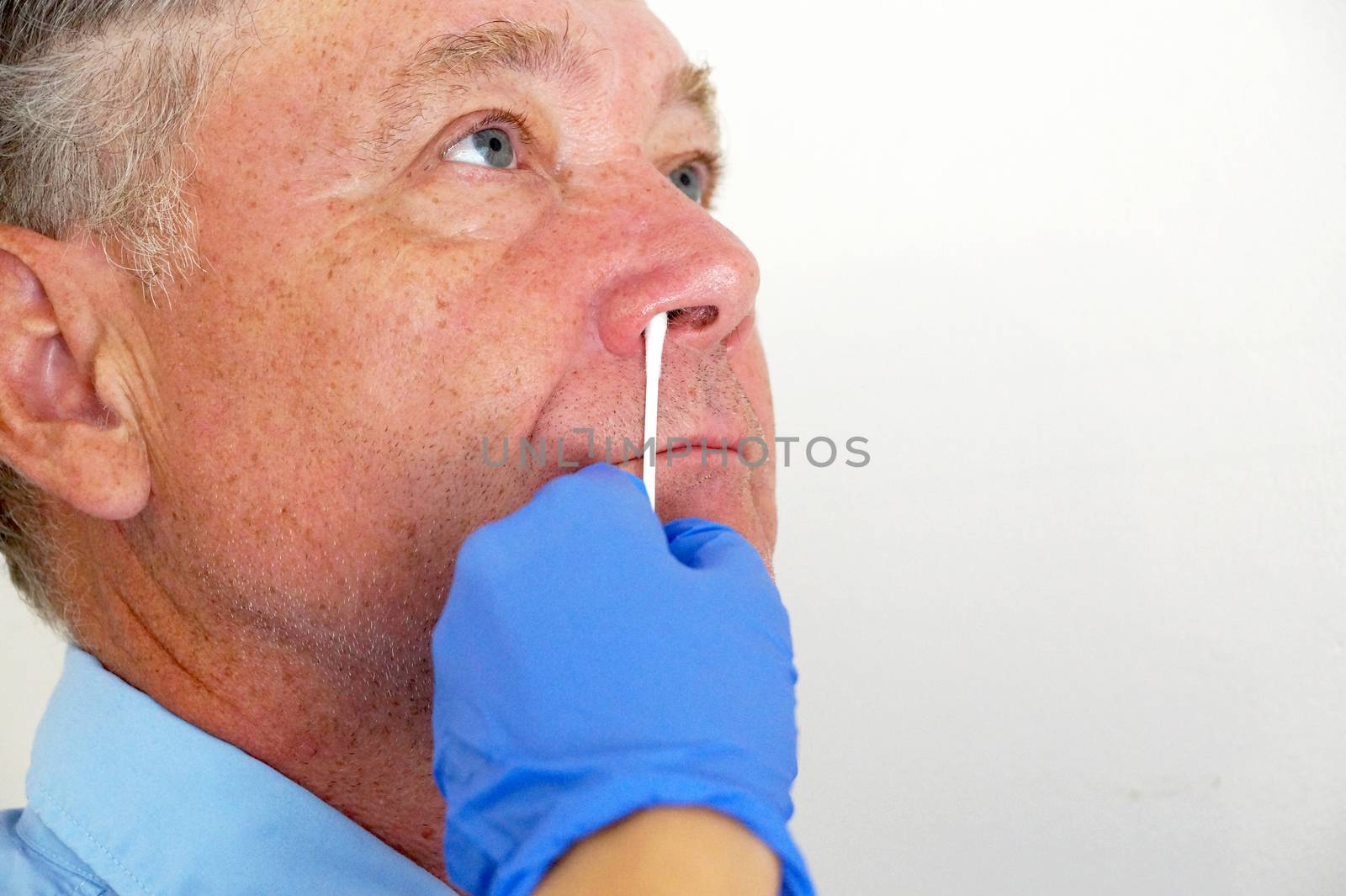 the doctor takes a test for coronavirus from the man's nose close up