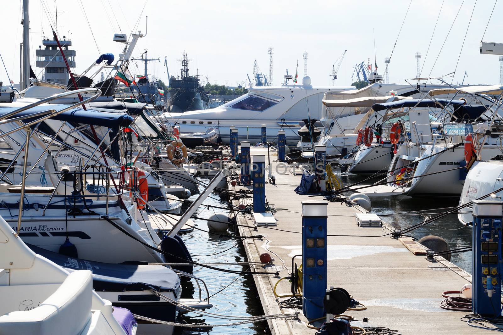 white yachts moored in the port against the backdrop of the sunset sky by Annado