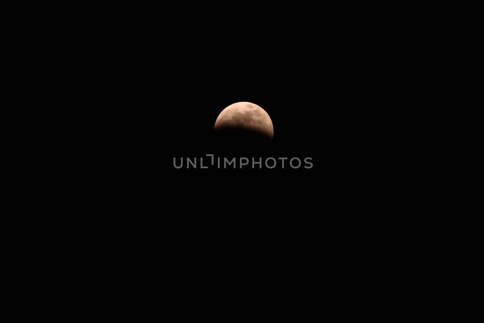 A Reddish Crescent Moon in a Pure Black Sky