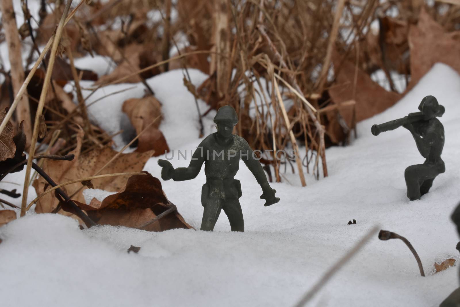 A Toy Soldier Holding a Pistol in a Deep Snowy Field