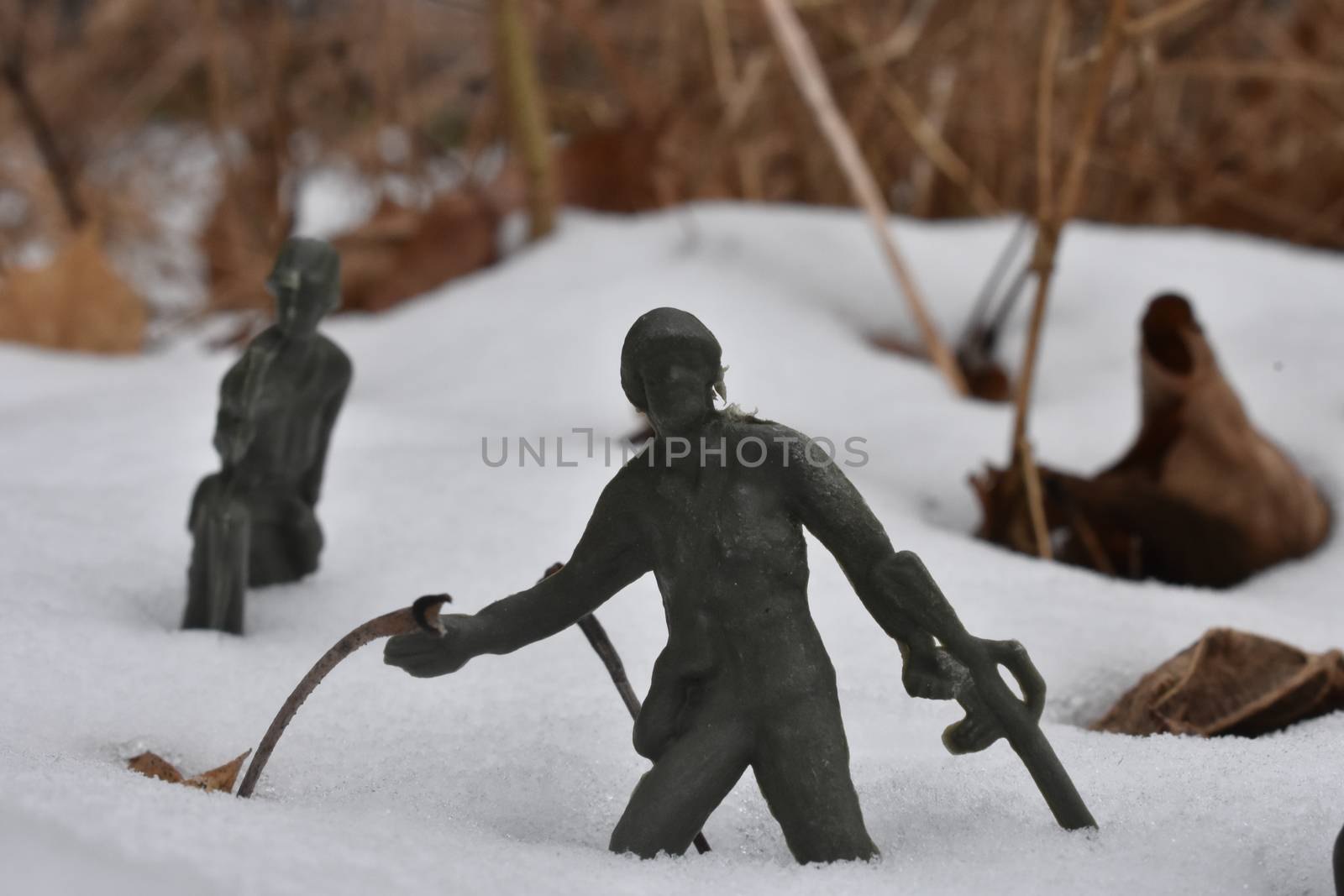 A Toy Soldier Leaning Back to Throw a Grenade in a Snowy Field by bju12290