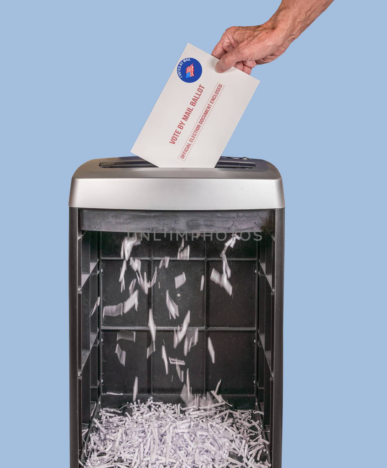 Absentee ballot of vote by mail envelope being shredded in an office shredder by steheap