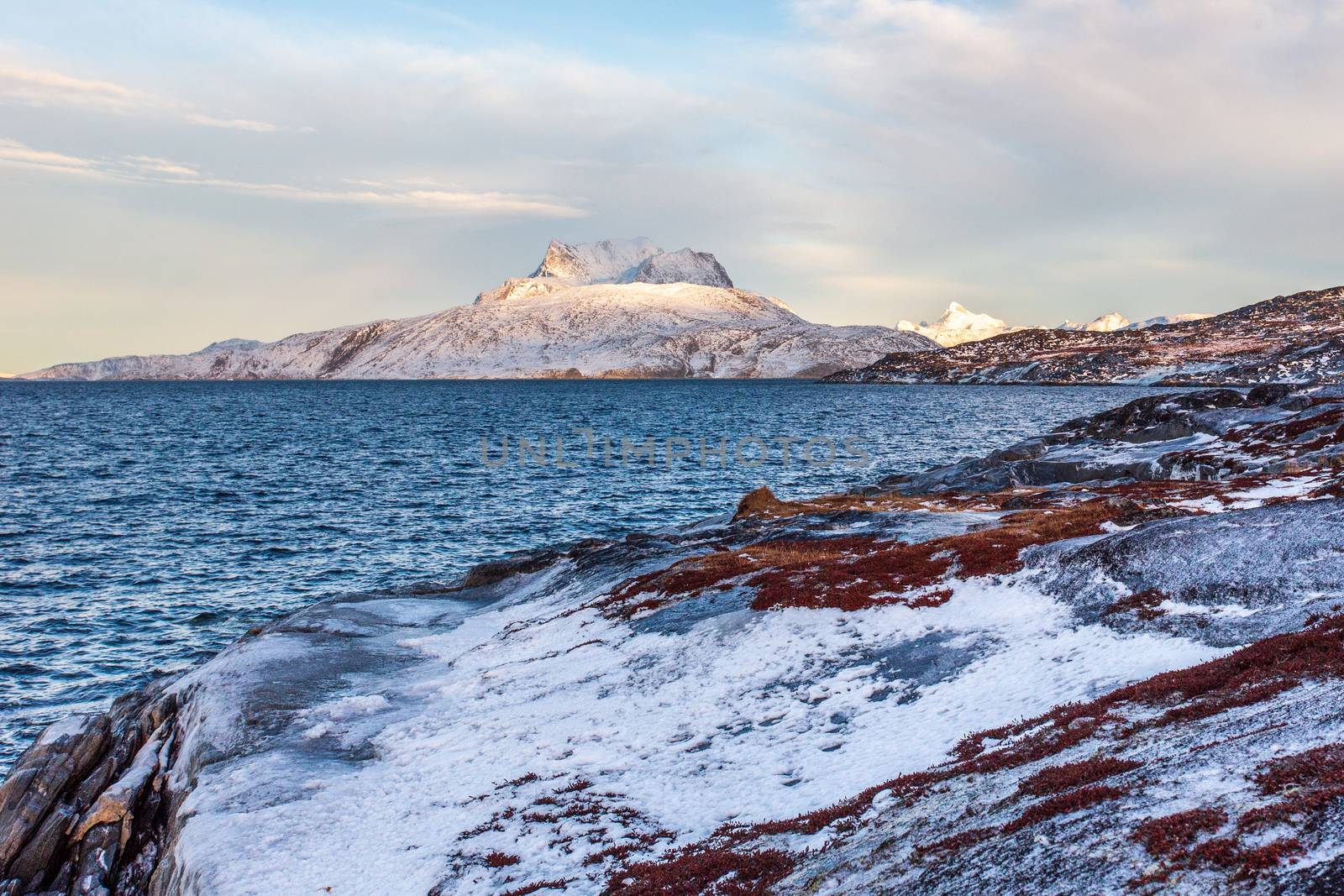 Frozen tundra landscape with cold greenlandic sea and snow Sermi by ambeon