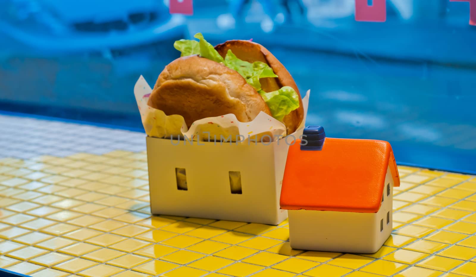 Freshly made burger fast food with soft toy orange house model by eyeofpaul