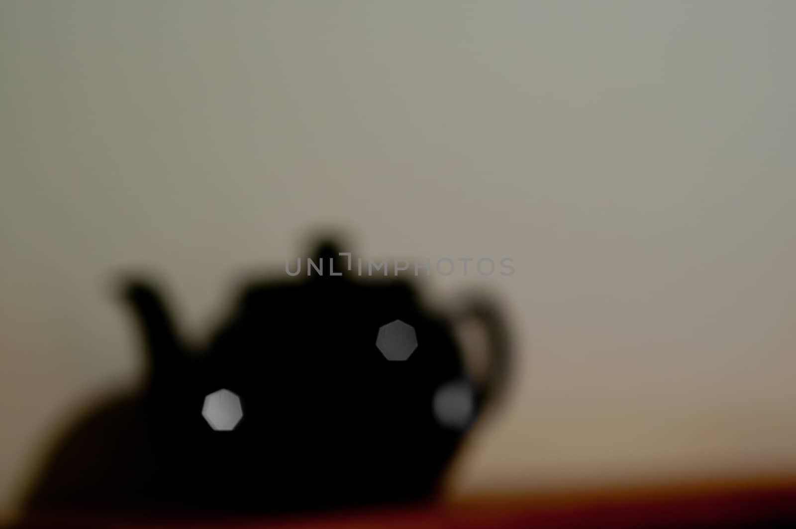 Defocused blurred black ceramic tea jug with copyspace