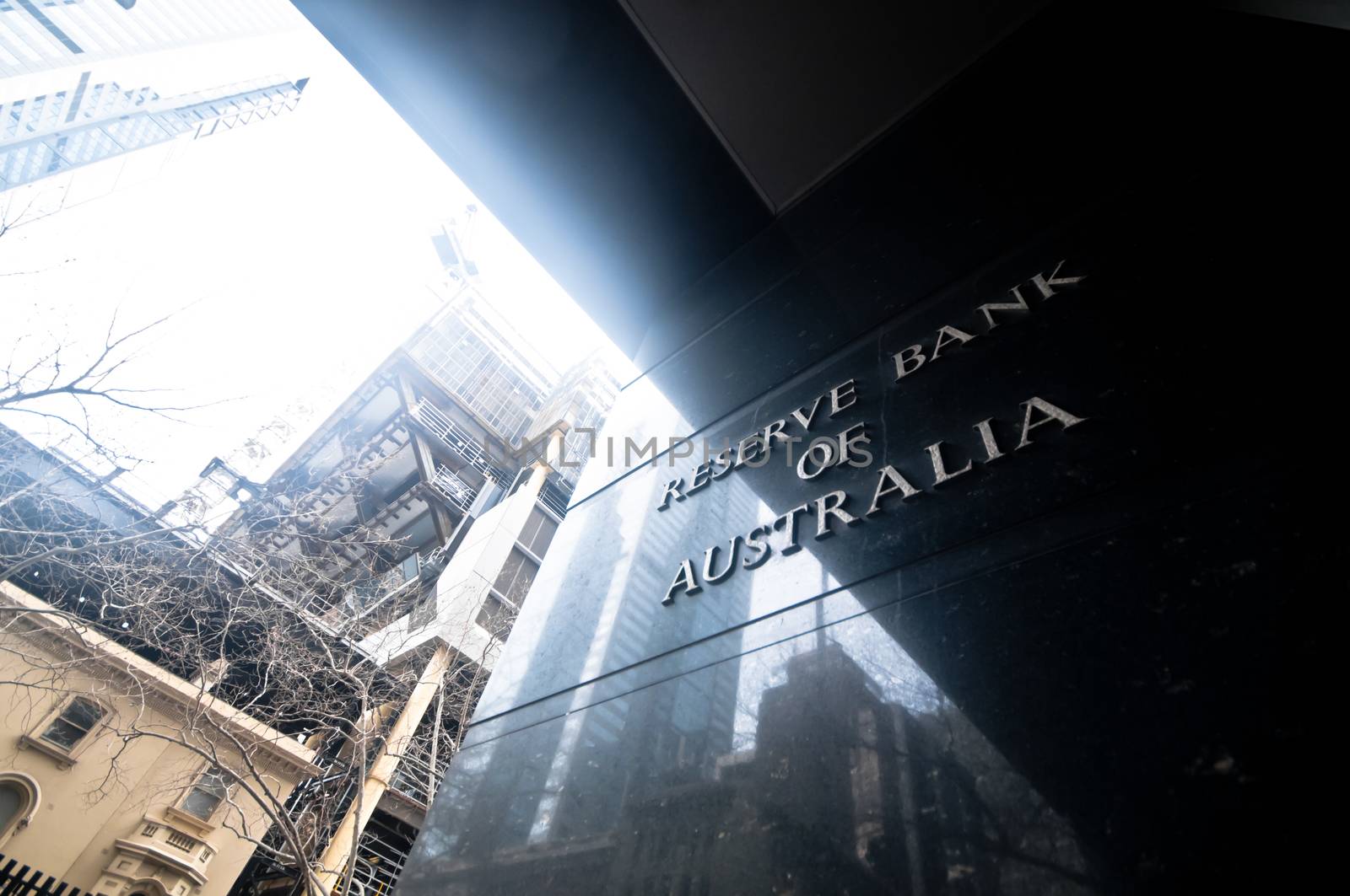 MELBOURNE, AUSTRALIA - JULY 26, 2018: Reserve Bank of Australia name on black granite wall in Melbourne Australia with a reflection of high-rise buildings. The RBA building is located at 60 Collins St, Melbourne VIC 3000 Australia.