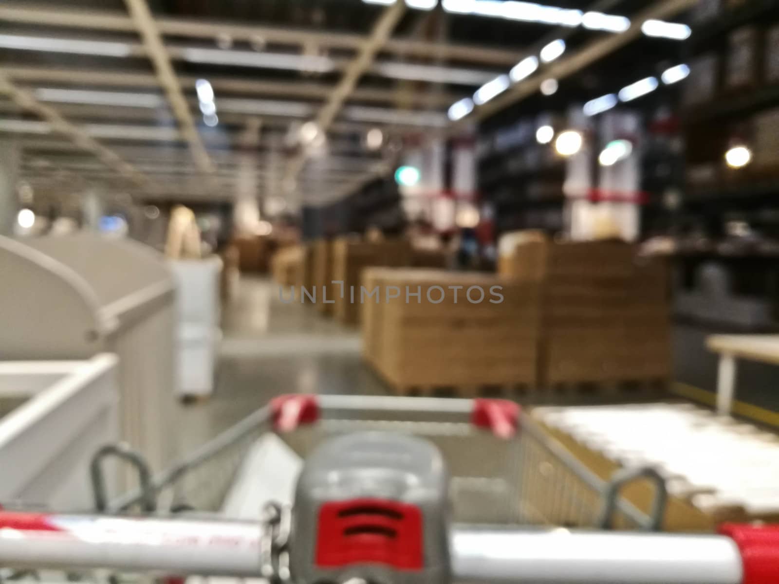 Defocused blurry scene of self pick and pack furniture warehouse shop with a cart
