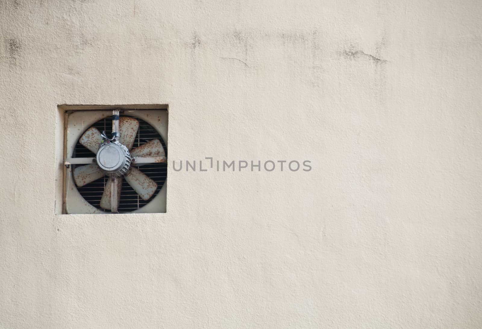 Old grey fan on creamy white wall by eyeofpaul