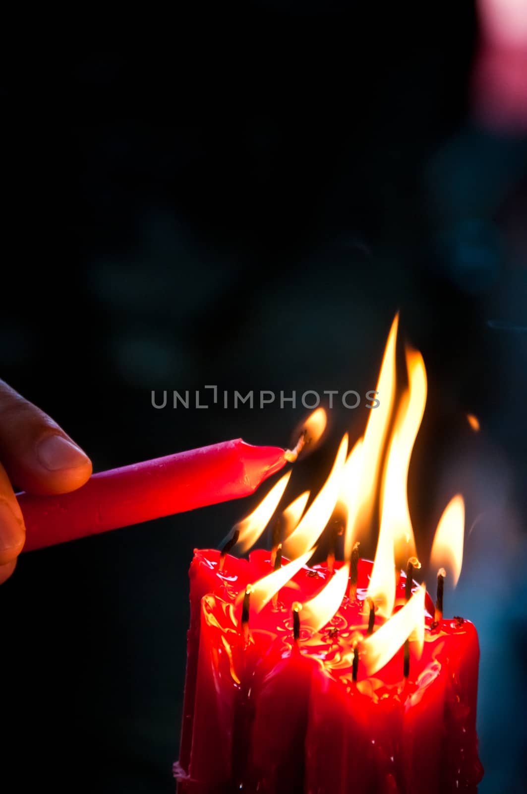 Hand lit red bright candles