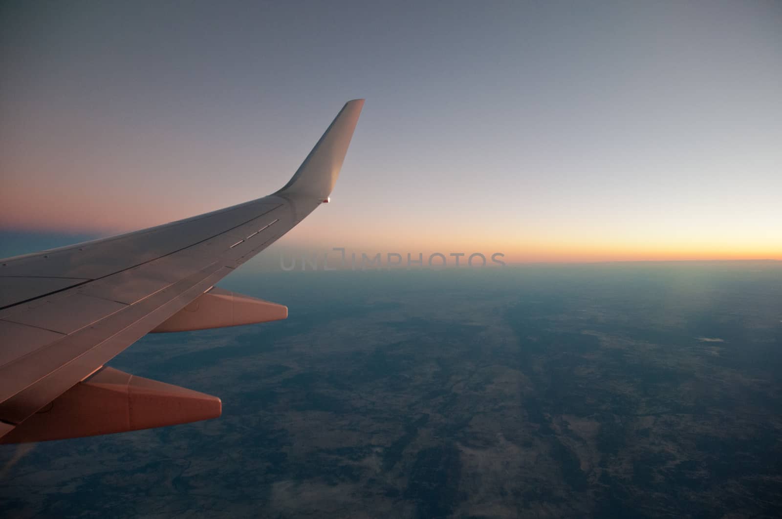 Sunset sky scene from plane window by eyeofpaul