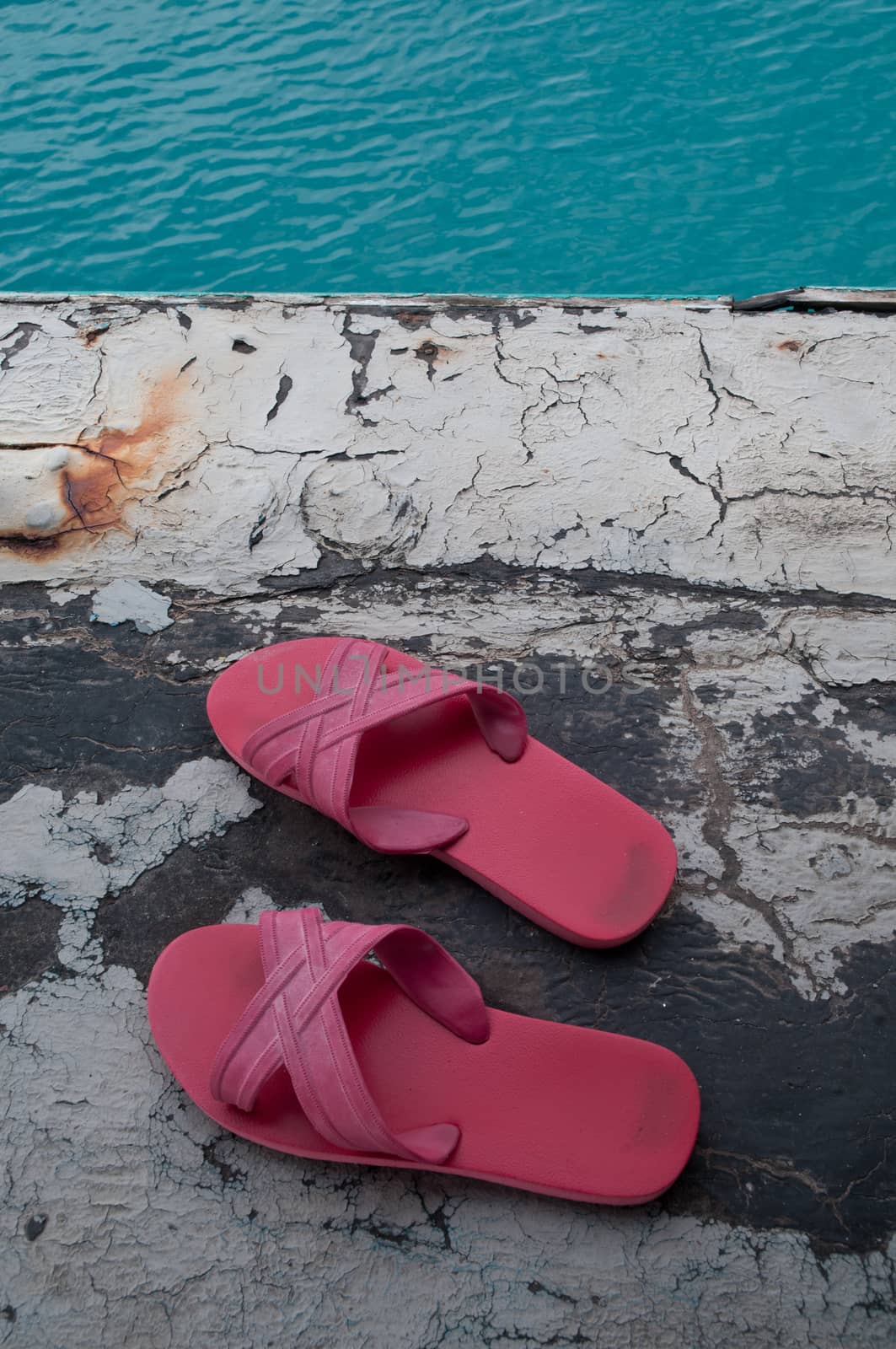 Red slippers on a floor above the sea by eyeofpaul