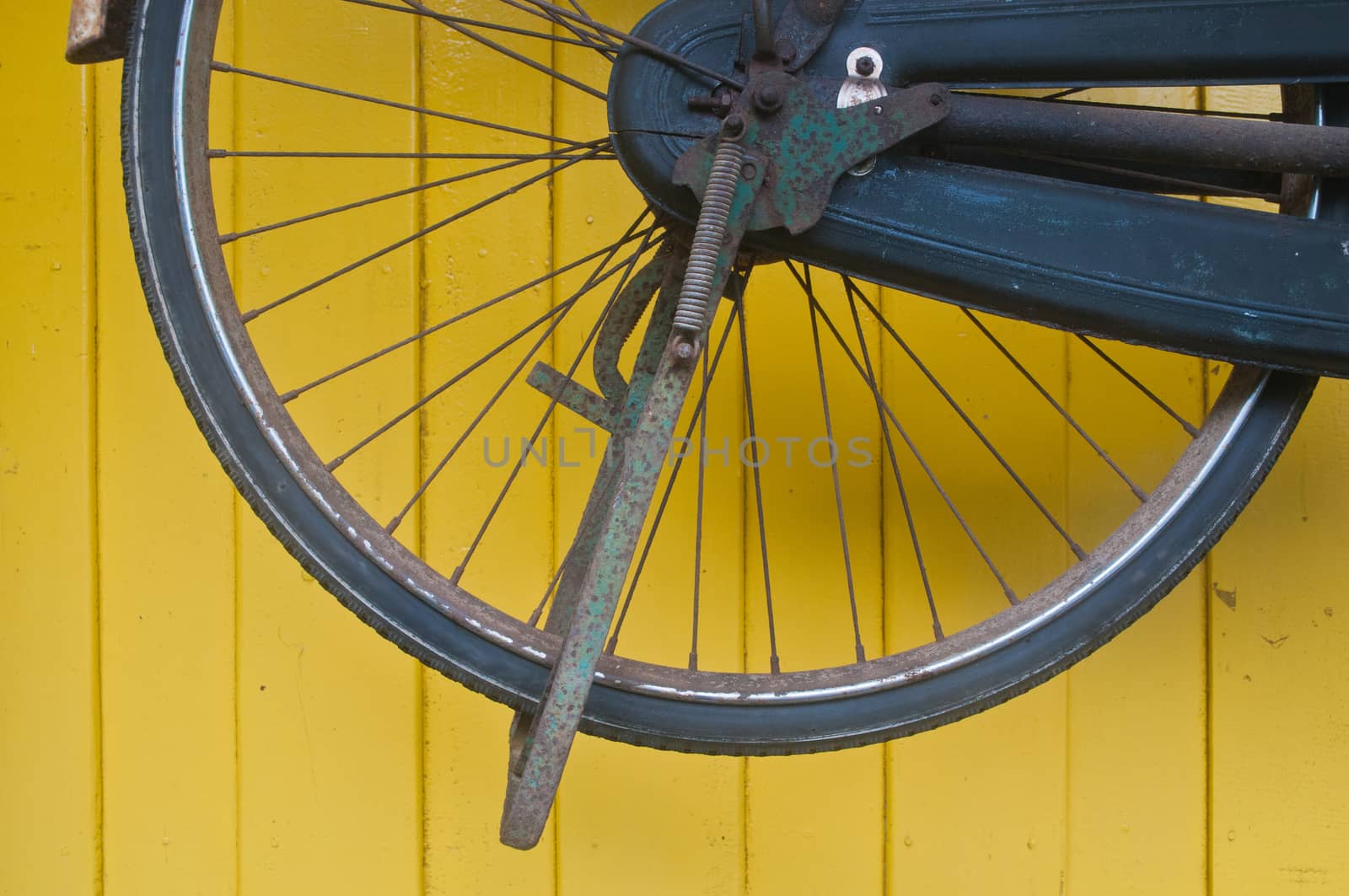 Classical bike wheel on yellow wall by eyeofpaul