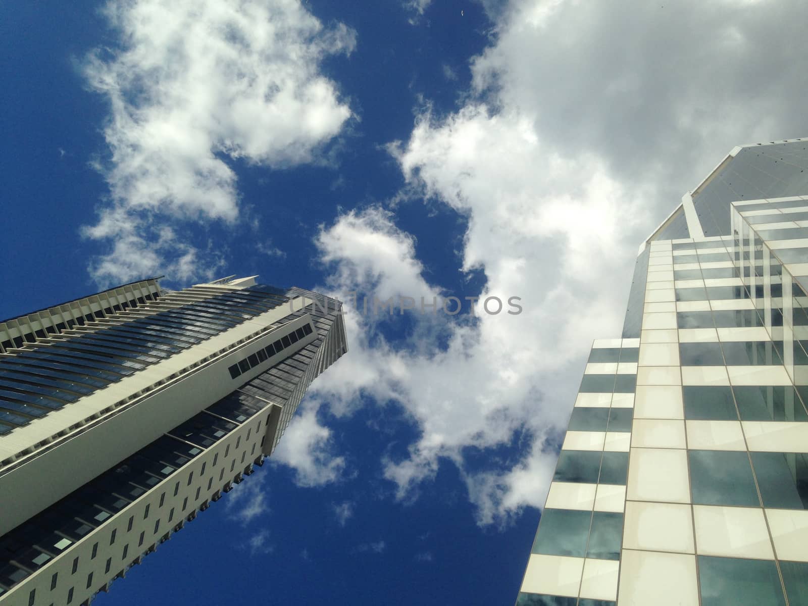 Look up to see blue sky and corporate office buildings