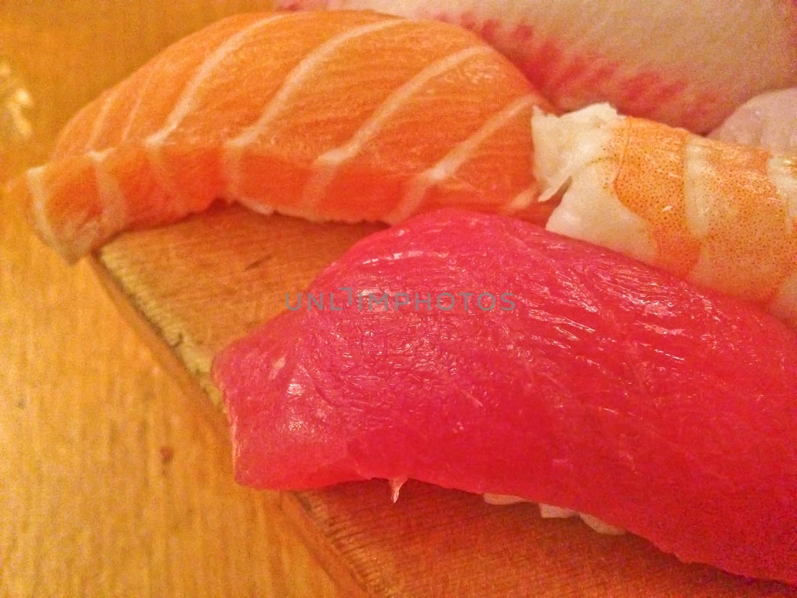 Mixed fresh Japanese sushi platter served on wooden plate and eat with chopsticks