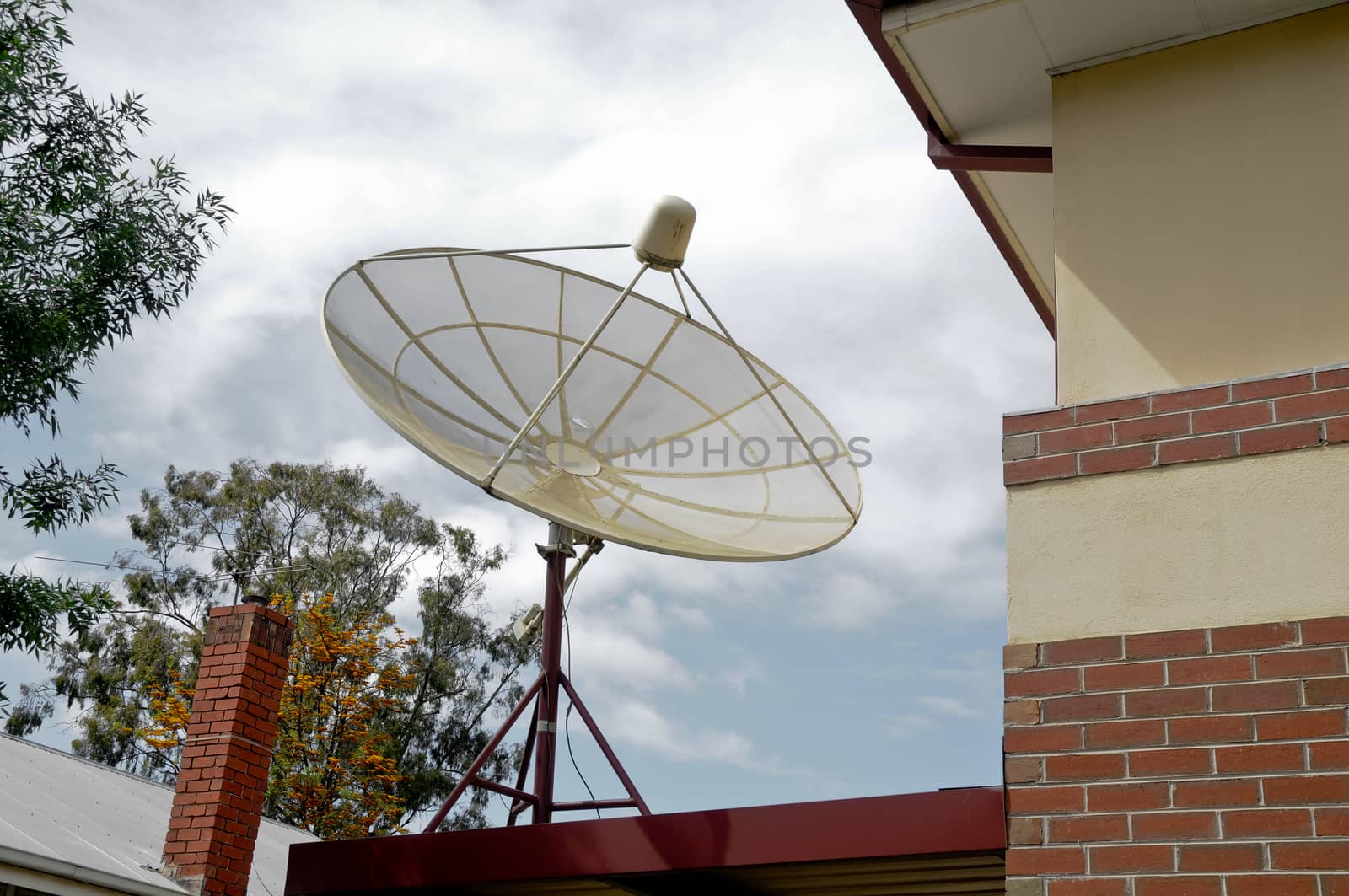 Satellite installed on a house in cloudy day by eyeofpaul