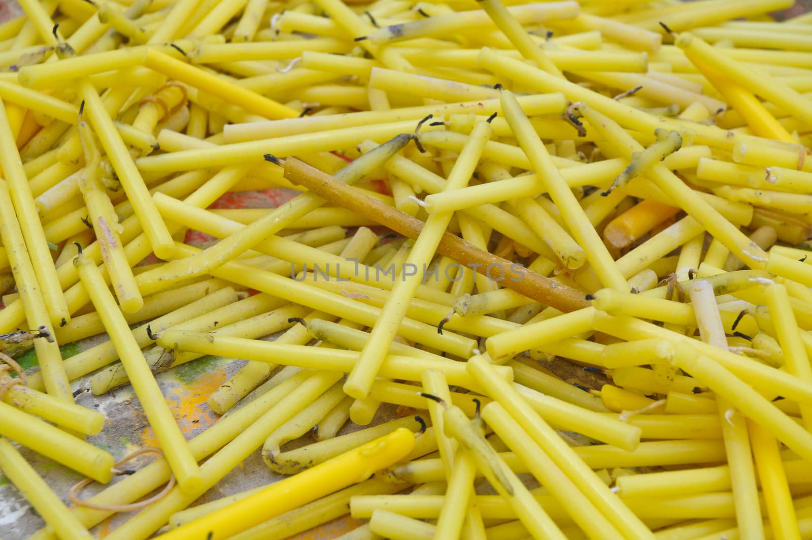 Close up of yellow candles for worshiping in temple by eyeofpaul