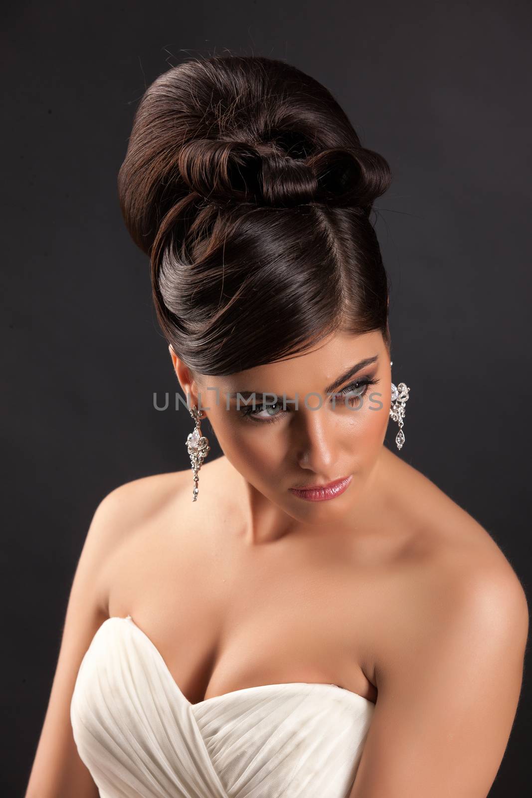 Young beautiful woman in a wedding dress on a black studio background