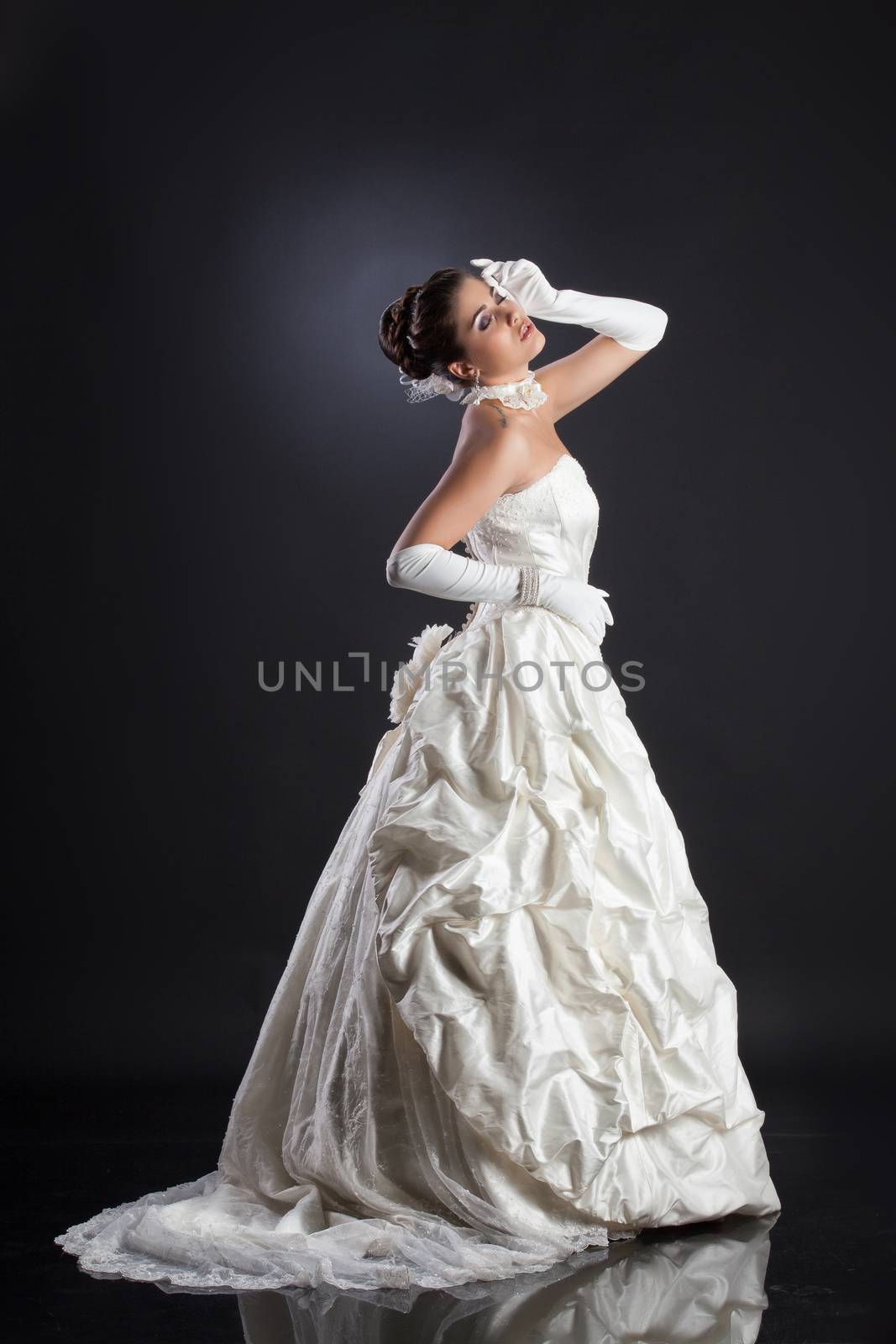 Young beautiful woman in a wedding dress on a studio background