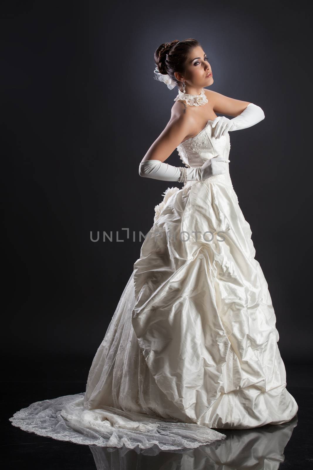 Young beautiful woman in a wedding dress on a studio background