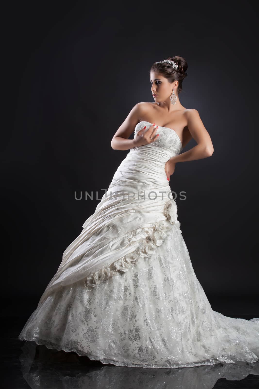 Young beautiful woman in a wedding dress on a studio background