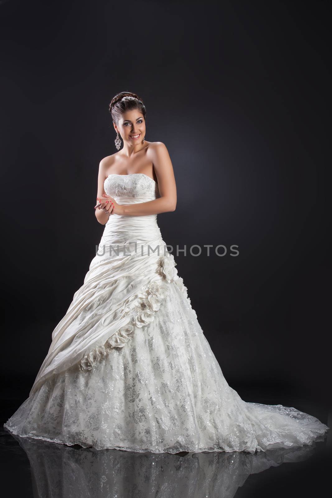 Young beautiful woman in a wedding dress on a studio background