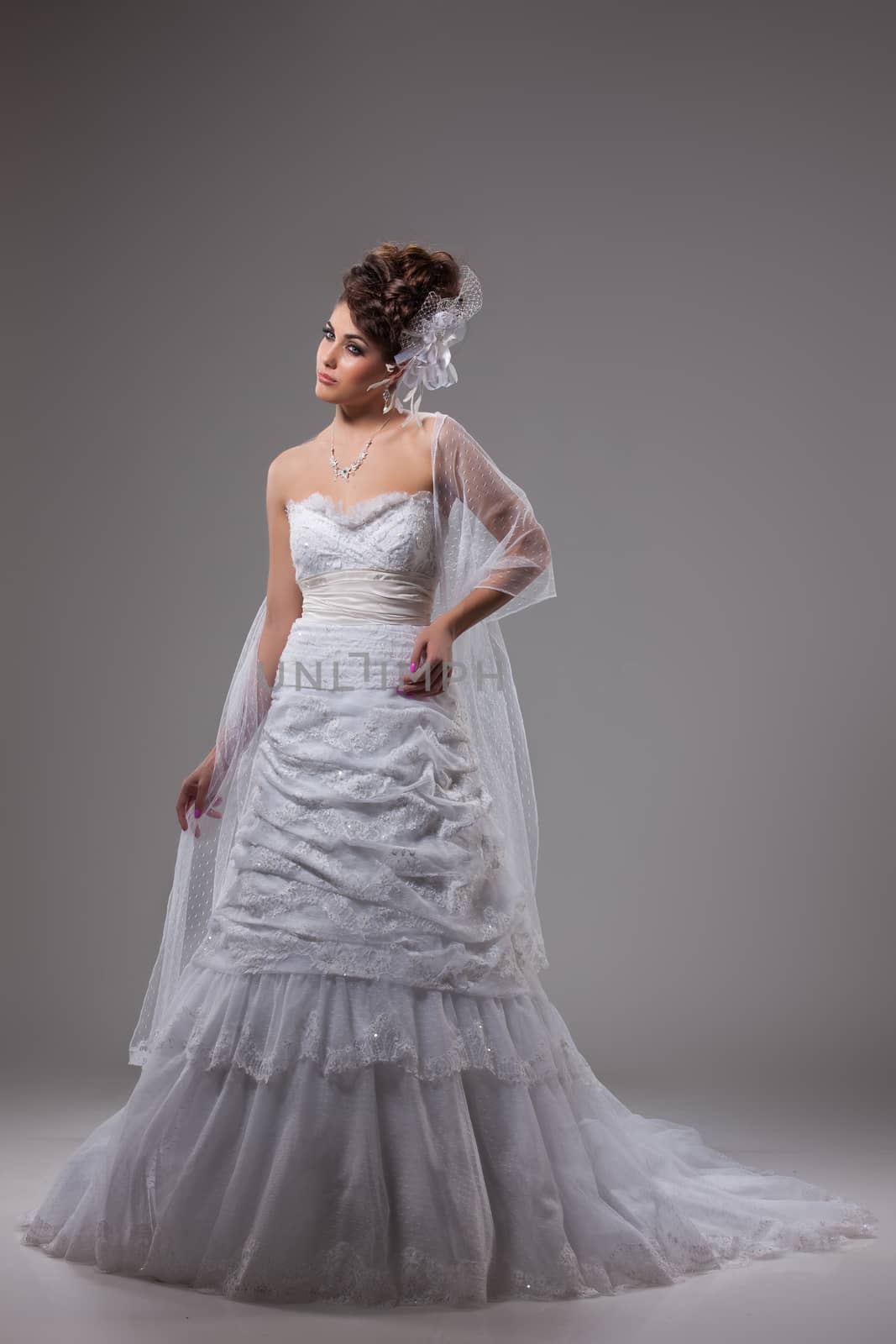 Young beautiful woman in a wedding dress on a studio background