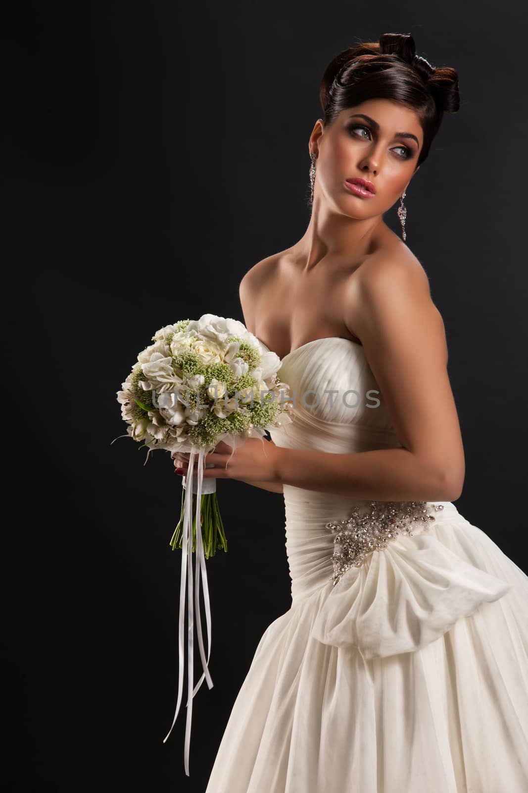 Young beautiful woman in a wedding dress on a black studio background