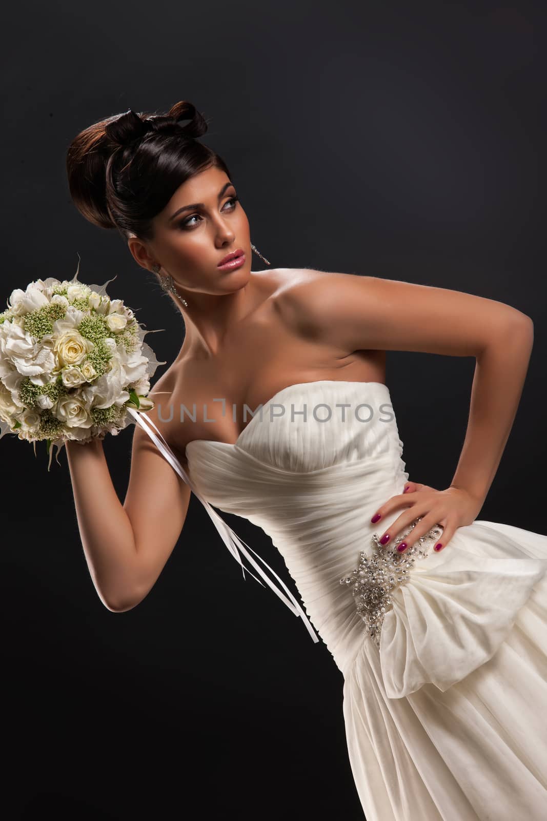 Young beautiful woman in a wedding dress on a black studio background