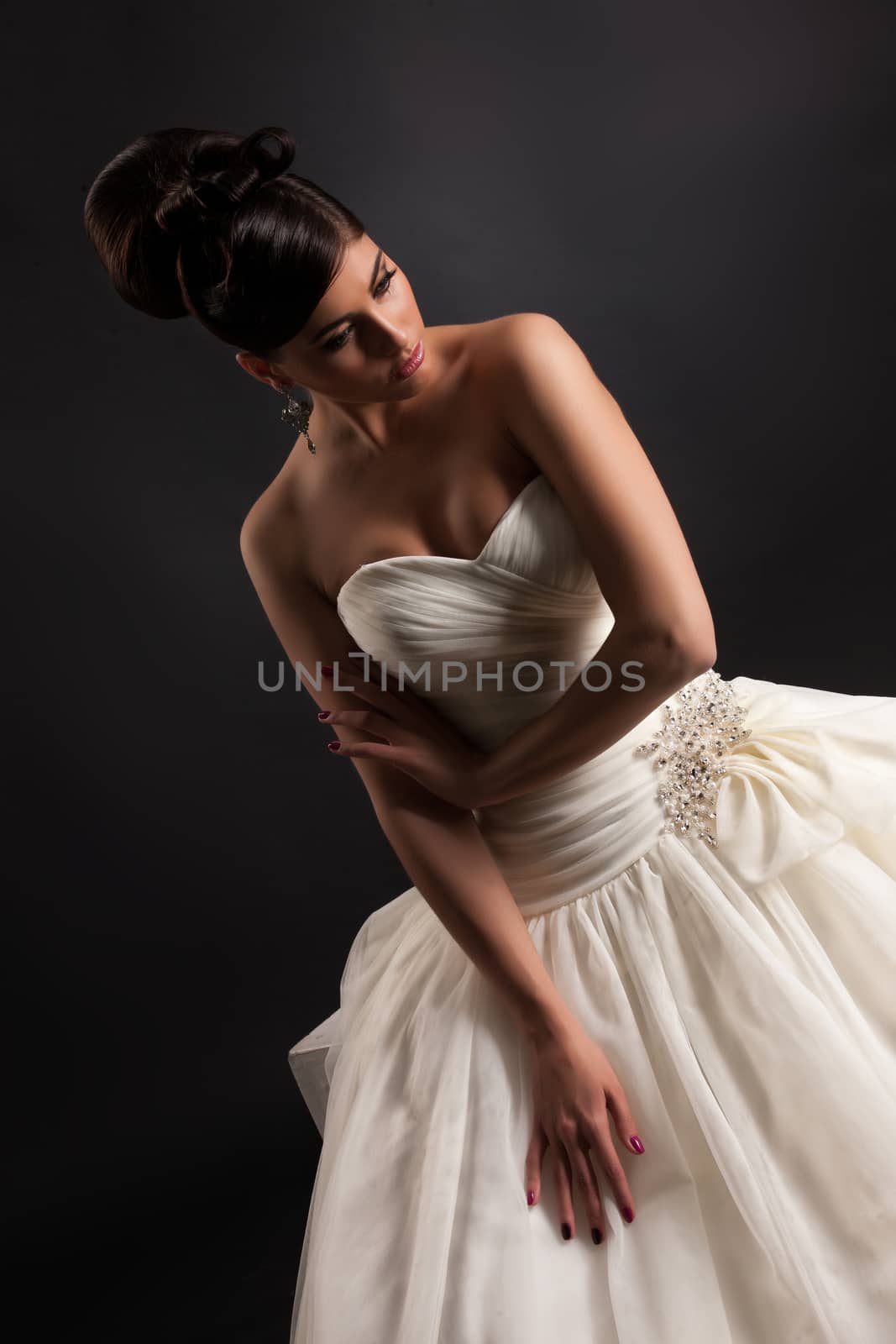 Young beautiful woman in a wedding dress on a black studio background