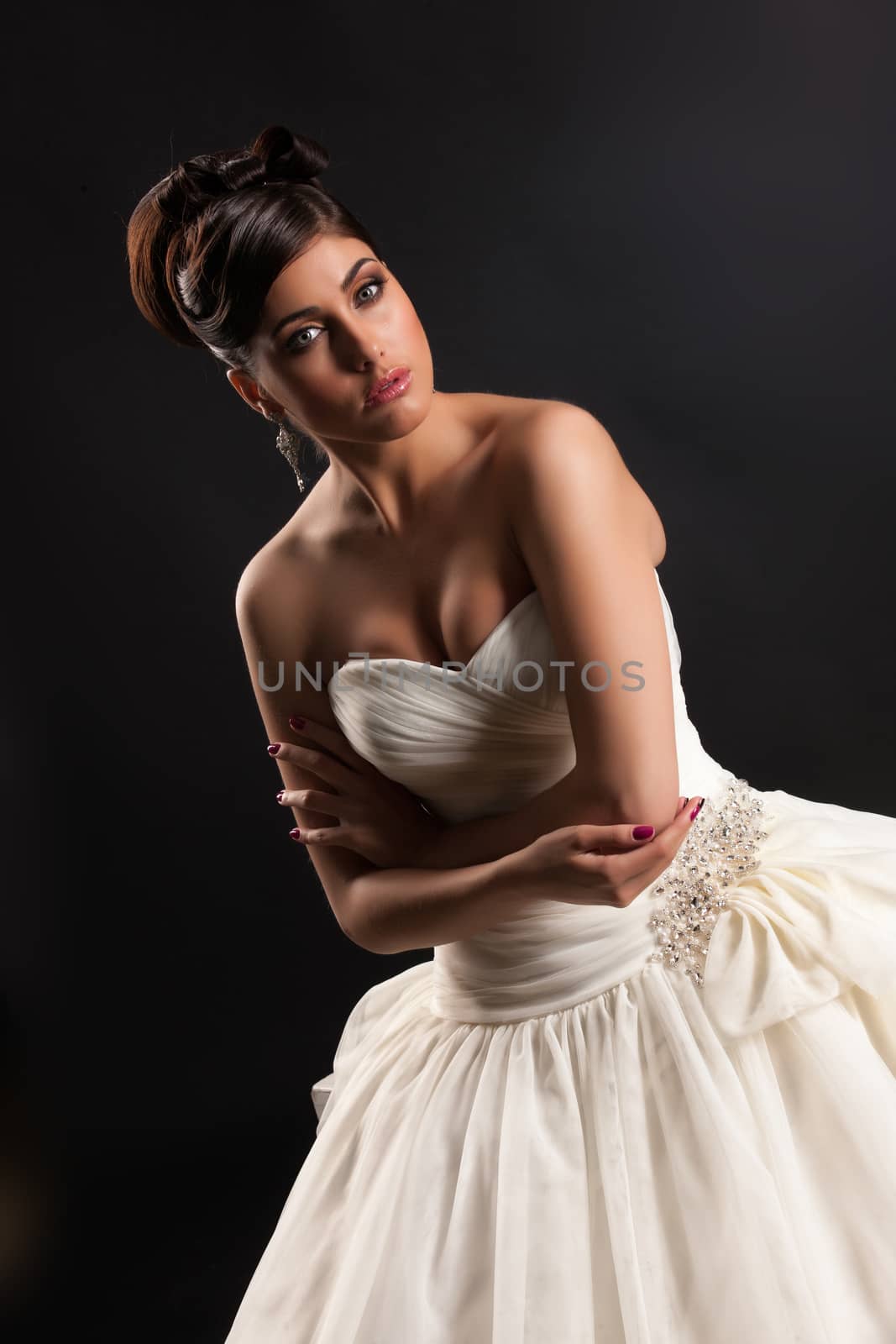 Young beautiful woman in a wedding dress on a black studio background