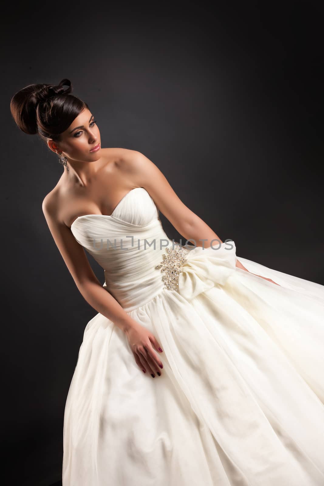 Young beautiful woman in a wedding dress on a black studio background