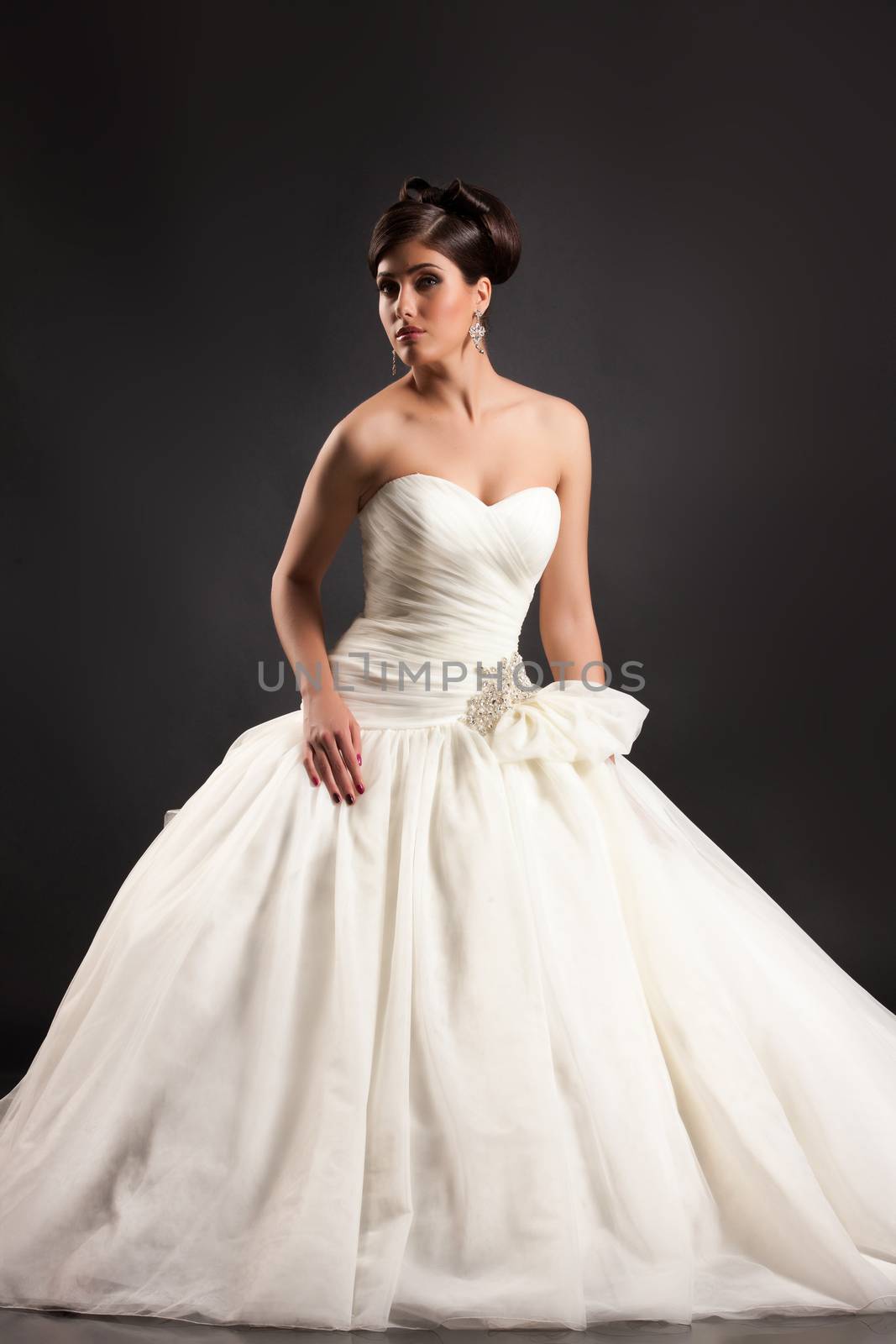 Young beautiful woman in a wedding dress on a black studio background