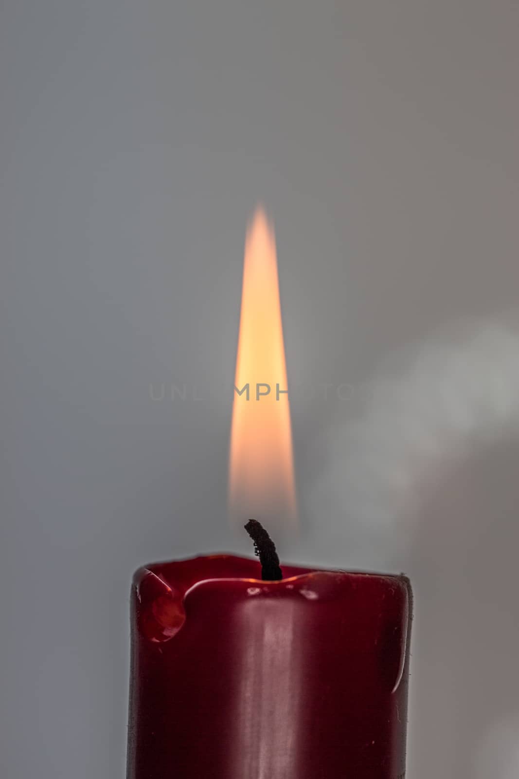 red candle burns with yellow flame