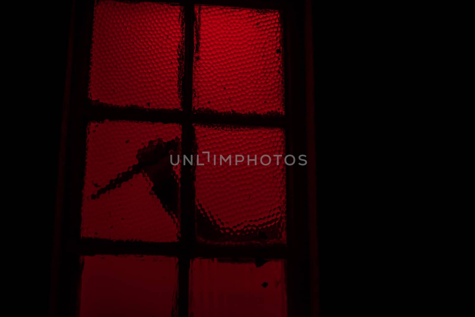 Silhouette of hand with knife seen in window