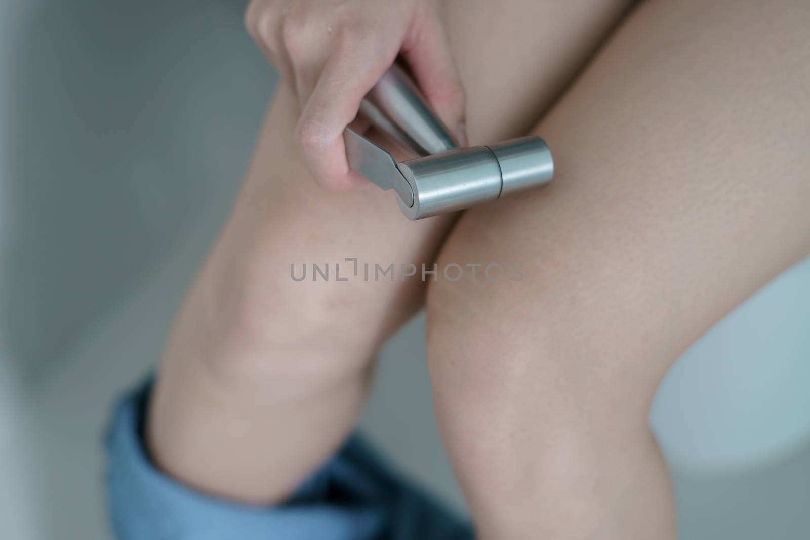 Woman hand using Chromium bidet shower sitting on toilet.