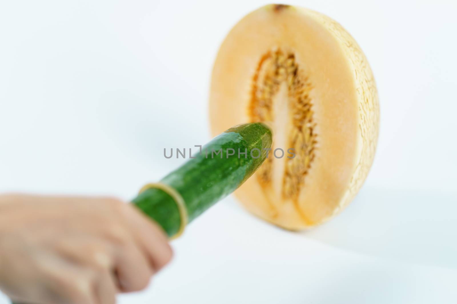 Melon and cucumber with condom on white background, Sex concept. by sirawit99