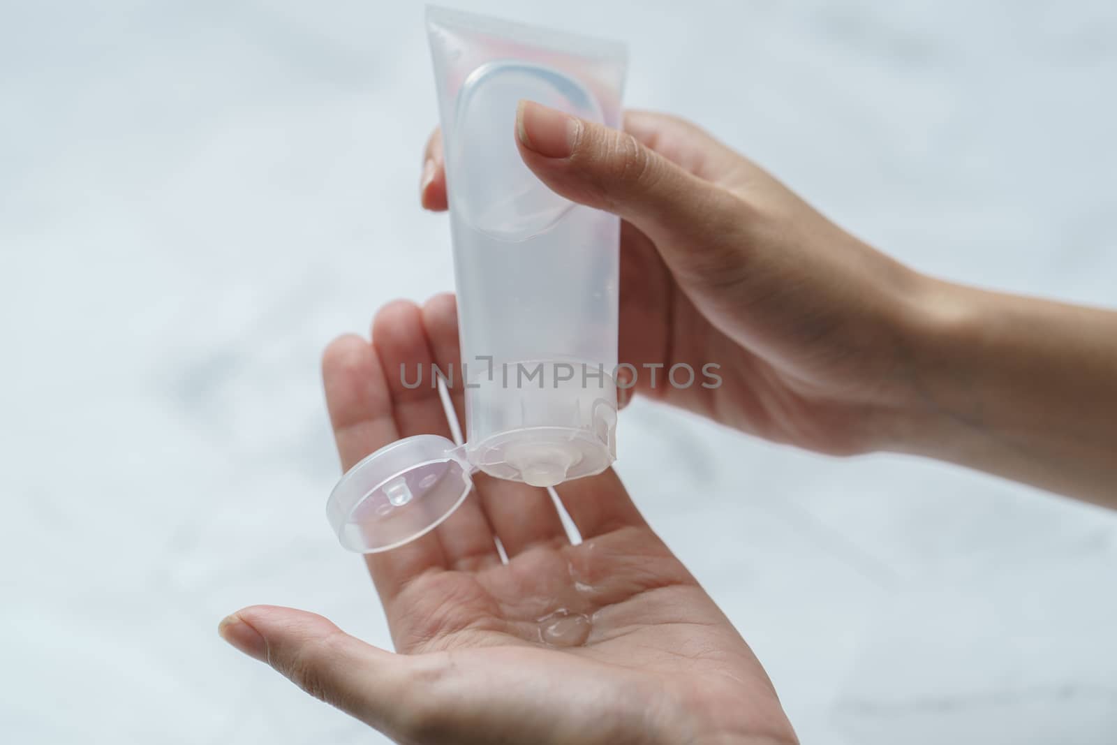 Close up woman using antibacterial hand sanitizer on hands.