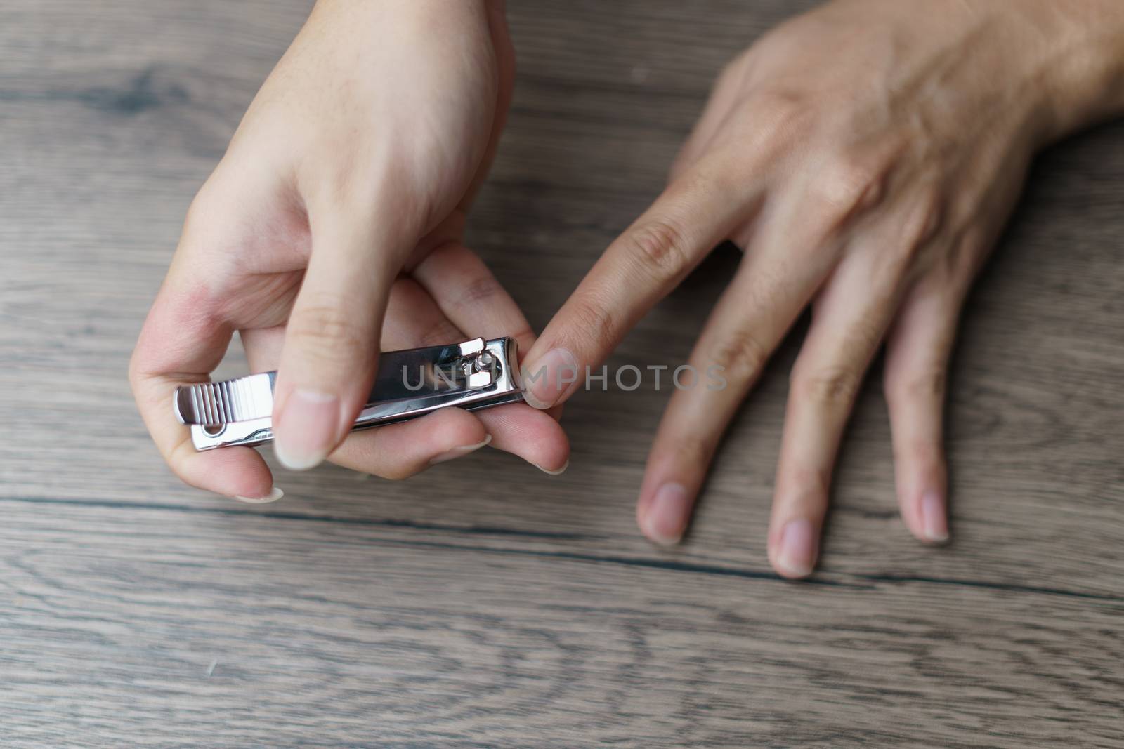 Man using nail clipper clipping her fingernails.