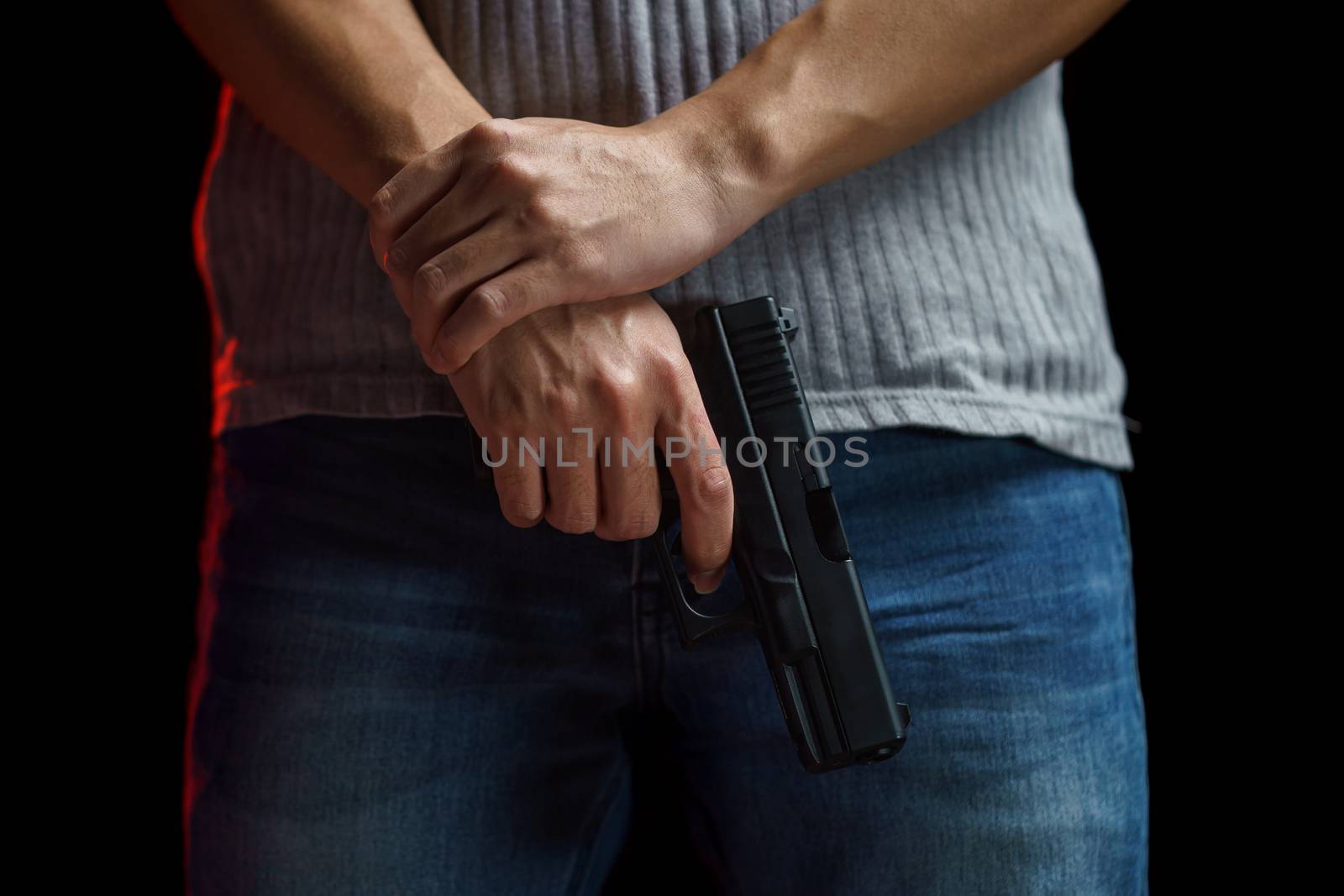 Man holding a gun on black background.