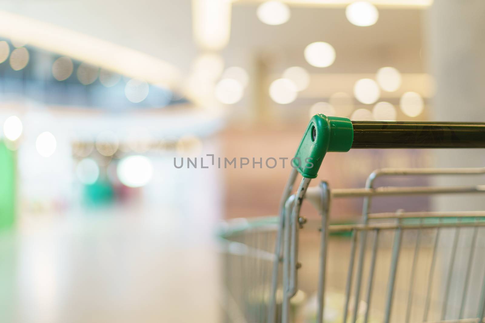Blurred of supermarket with empty shopping cart. by sirawit99