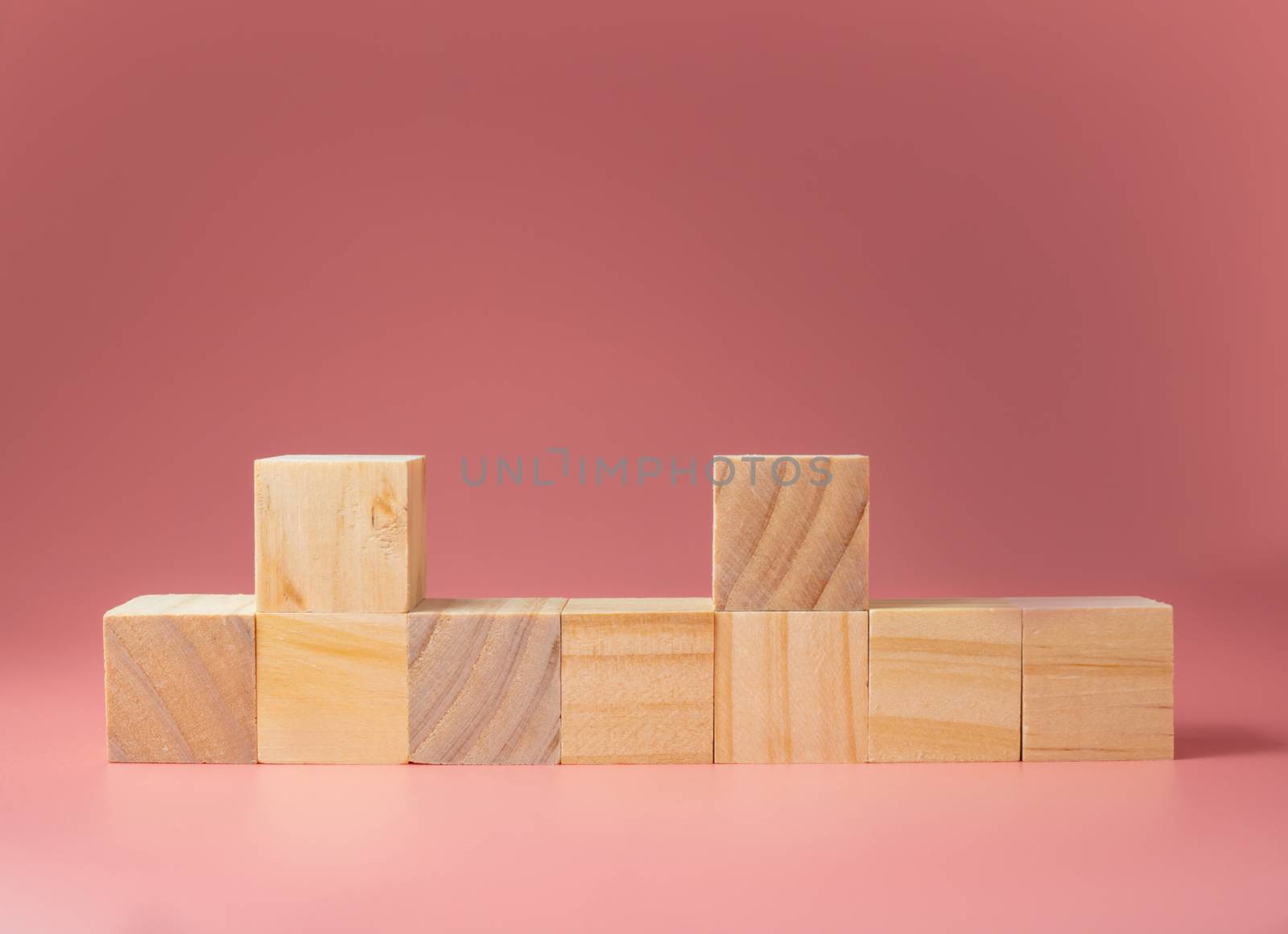 A wooden cube on a pink background.For new ideas to be put into by Unimages2527