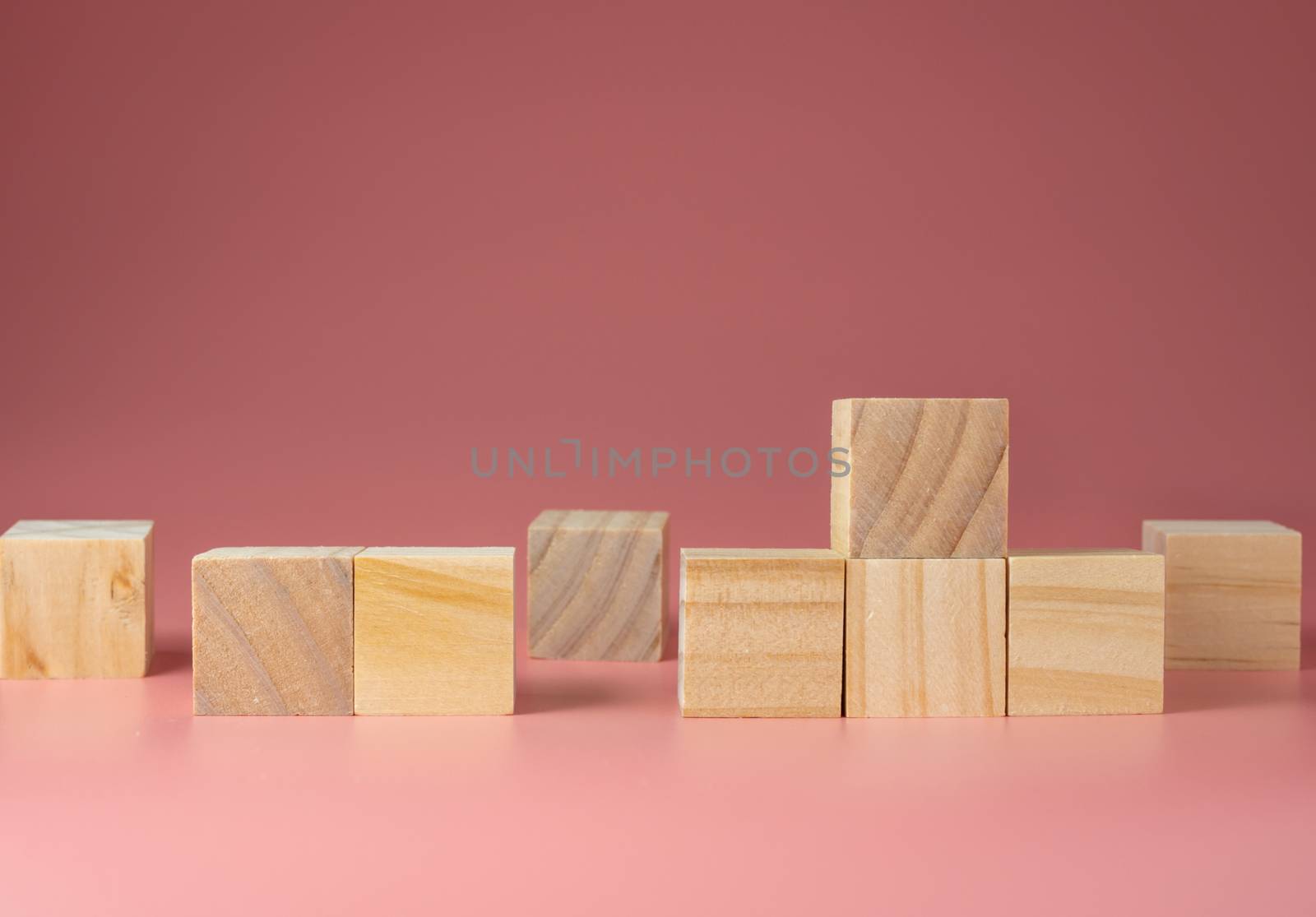 A wooden cube on a pink background. For new ideas to be put into the picture.