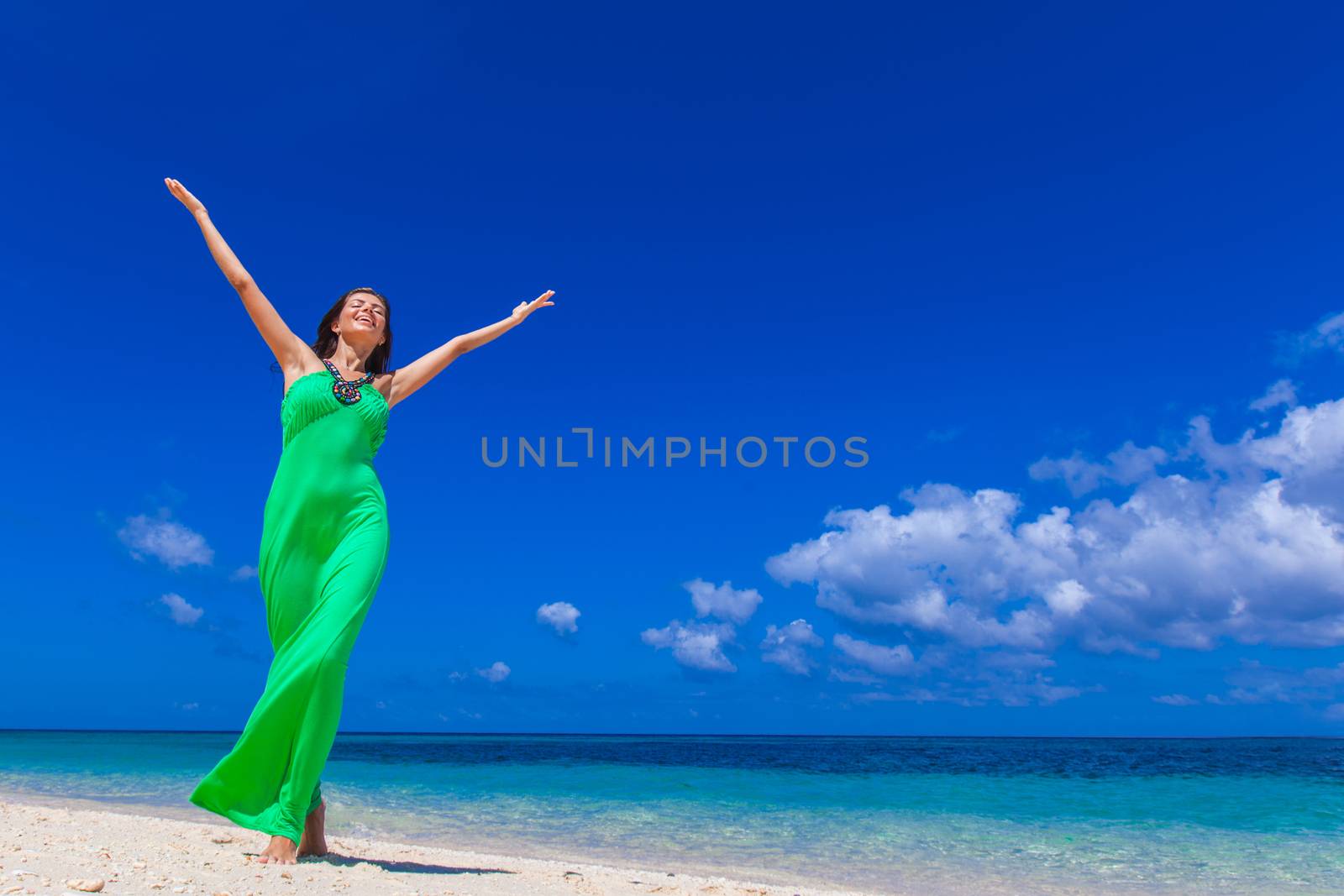 Happy smiling woman enjoy vacation on beach with raised hands