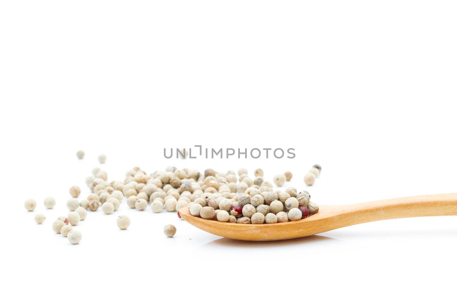 Pepper spices in a wooden spoon on a white background  