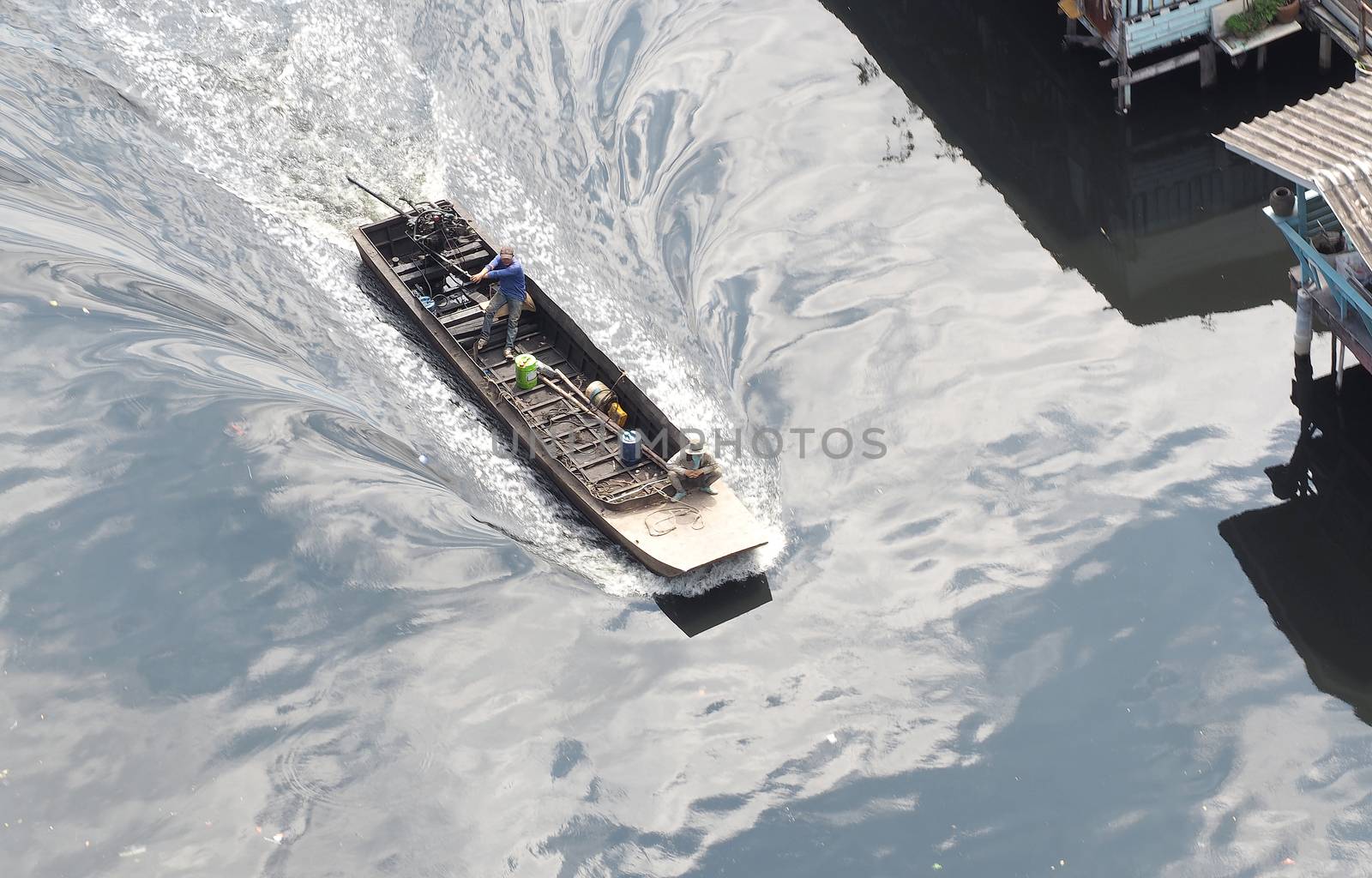 Small old long tailed boat and asia man and sailing in the small river.