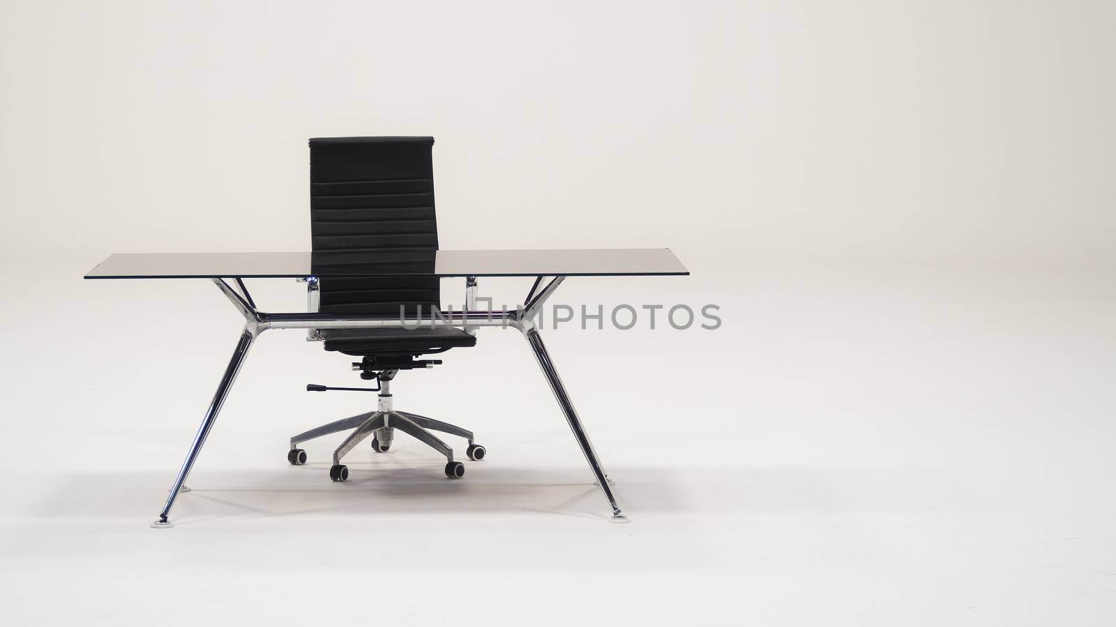 Table with top glass and leather armchair for work and white background.