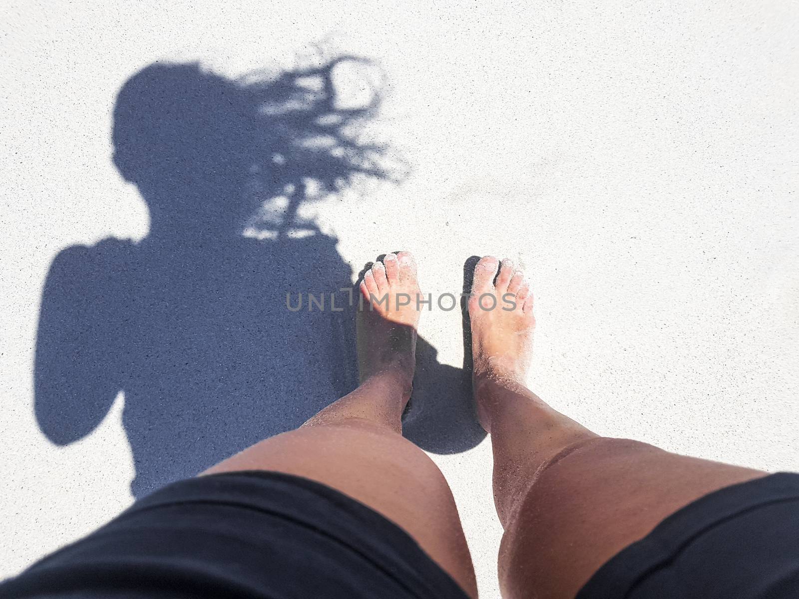 Woman barefoot on sand in Camps Bay. by Arkadij