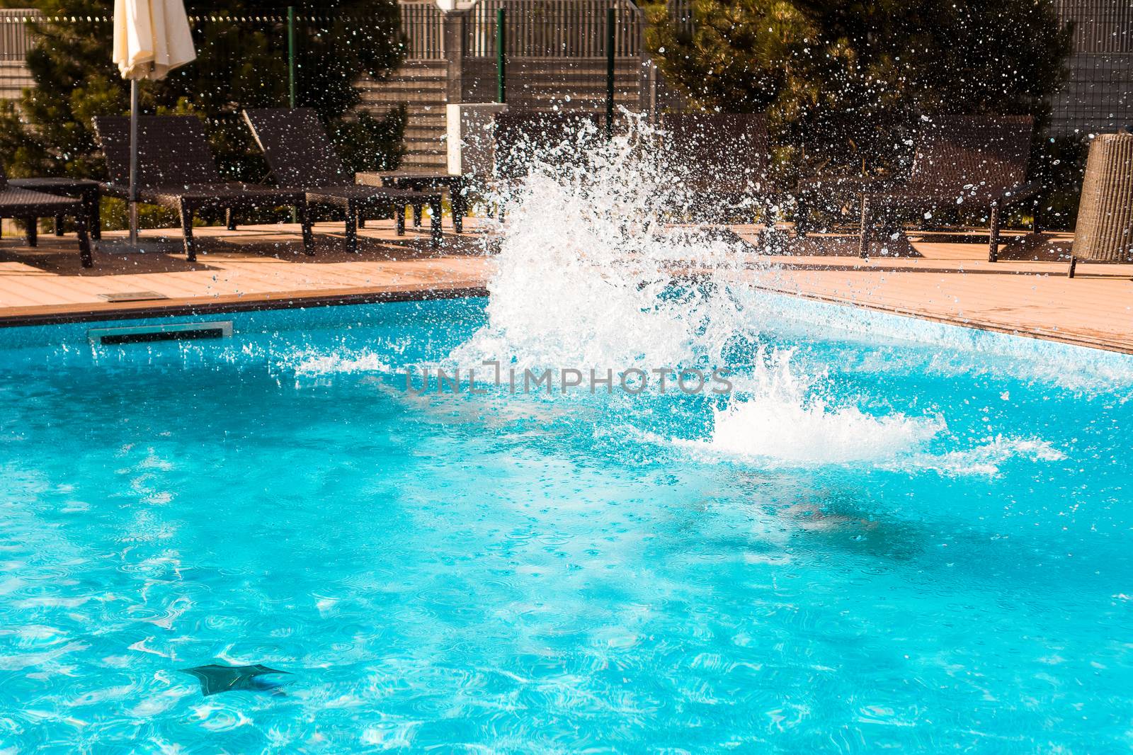 Pool fun. Jumping into the outdoor swimming pool with clear blue water