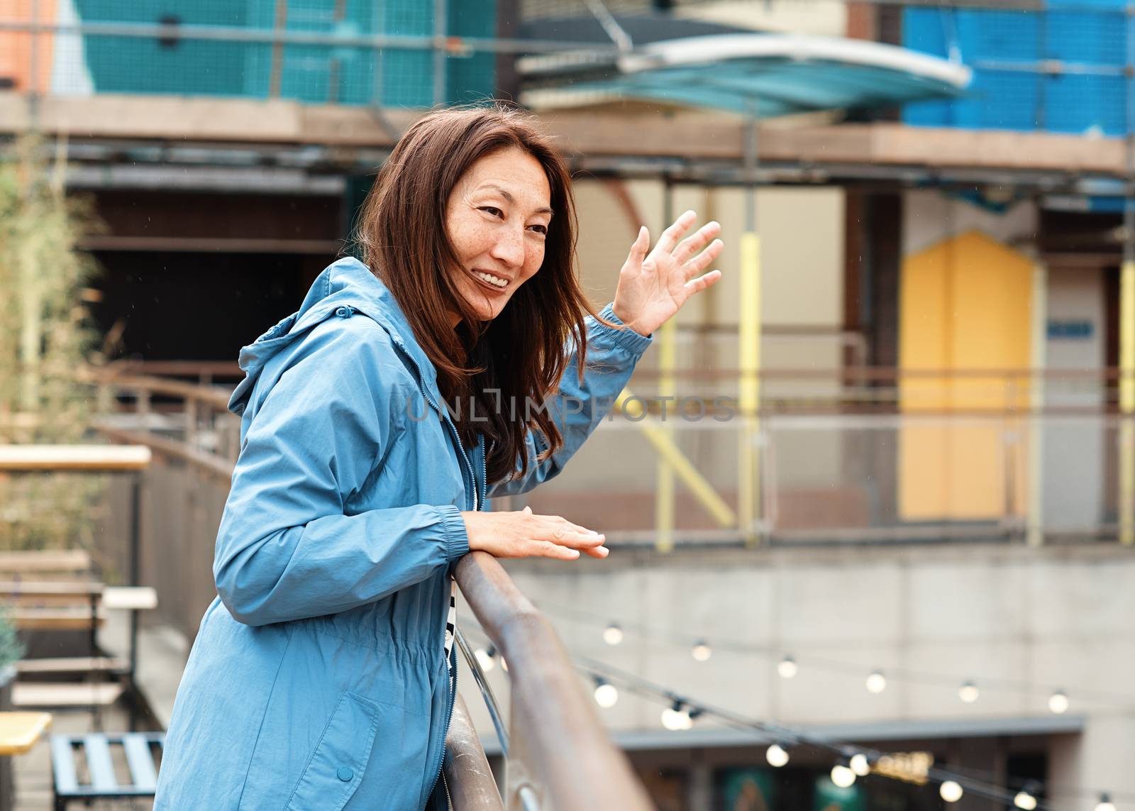 Asian woman in a blue coat walking around Europe city